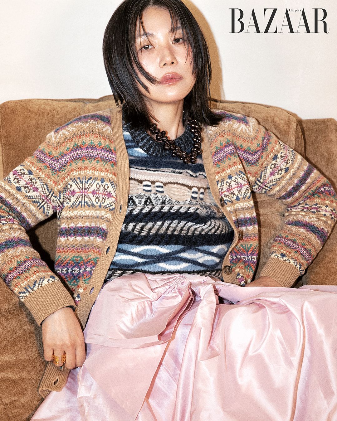 카디건은 Lauren Ralph Lauren. 니트 톱은 Claudie Pierlot. 스커트는 Coach. 목걸이는 H&M. 반지는 Loewe.
