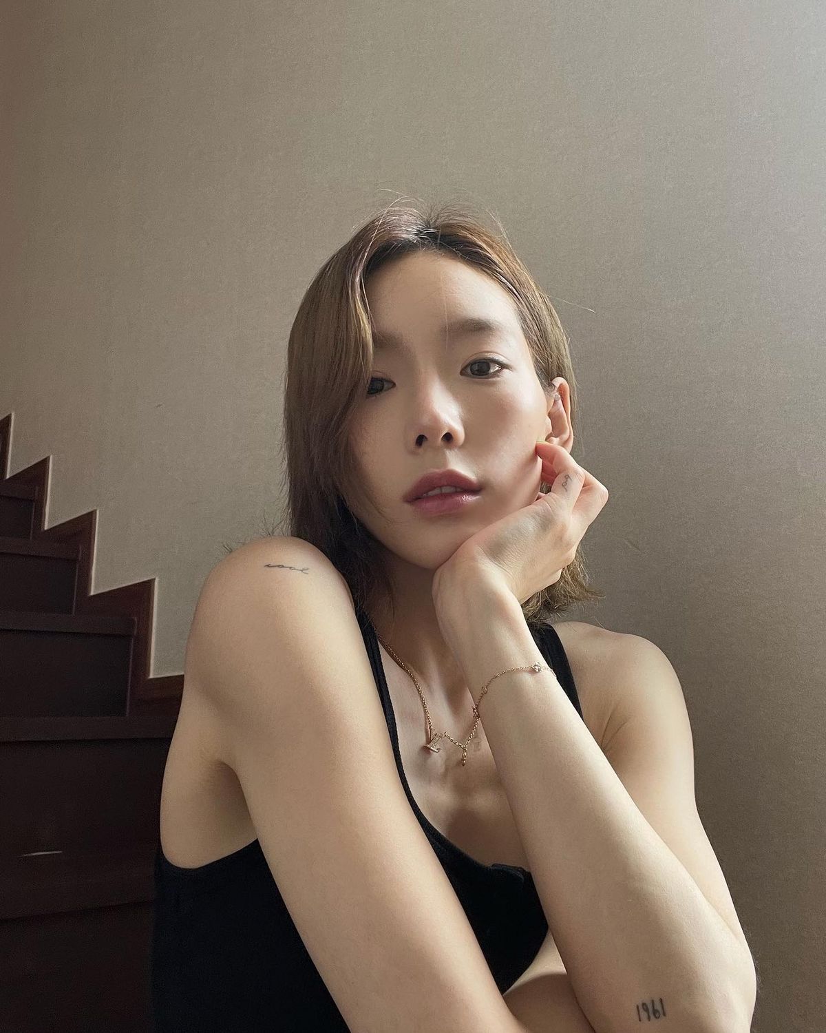 심플한 블랙 슬리브리스로 미니 타투를 은근히 드러낸 태연. @taeyeon_ss 