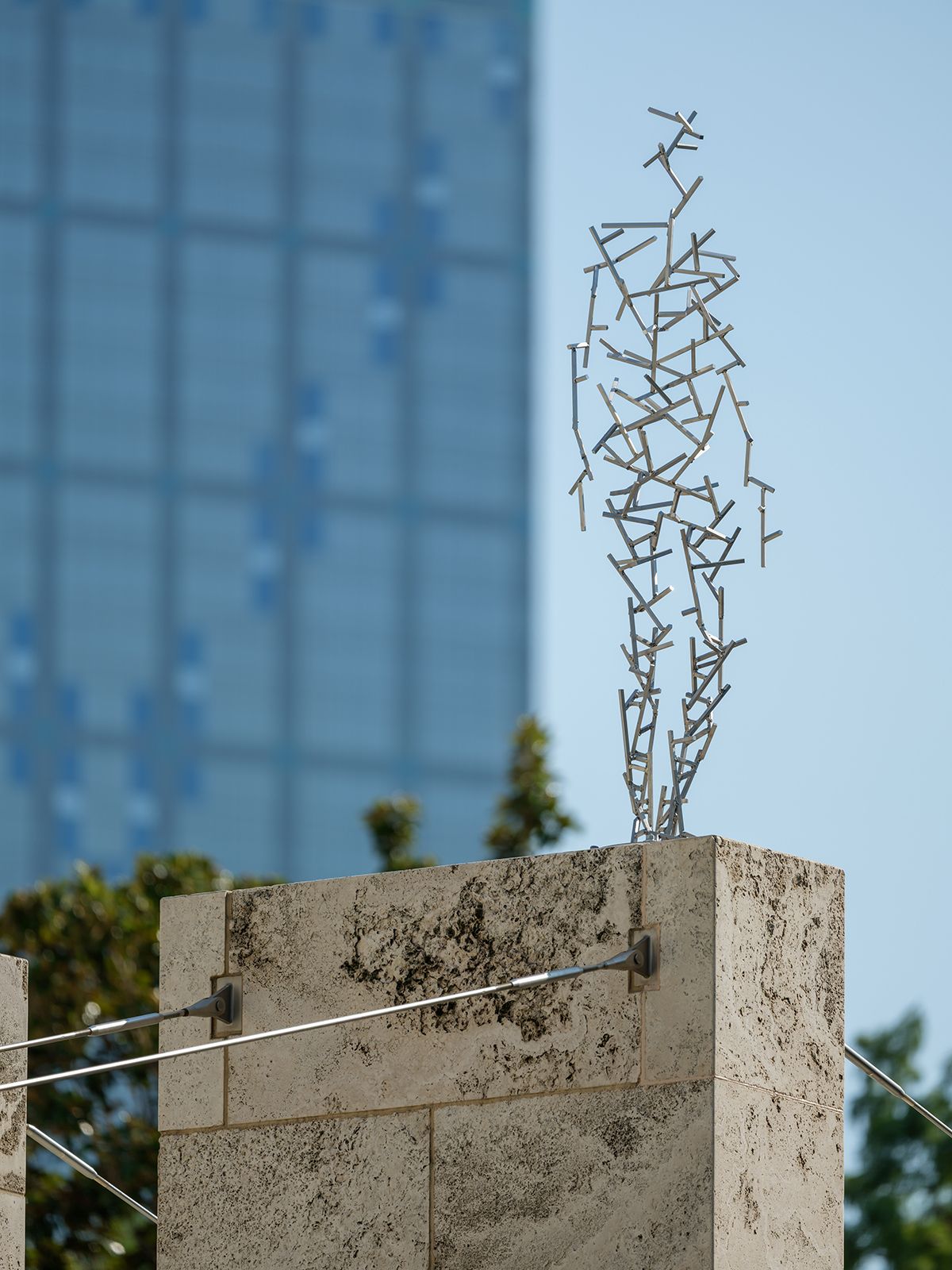 내셔 조각 센터 건물 외벽에 설치된 안토니 곰리의 작품 <Domain XCVI>. Antony Gormley, <Domain XCVI>, 2025. Stainless steel. 189.5x66.2x35.7cm. © Antony Gormley. Installation view of SURVEY: Antony Gormley, Nasher Sculpture Center, Dallas, Texas, September 13, 2025–January 4, 2026. Photo by Kevin Todora, courtesy of the Nasher Sculpture Center