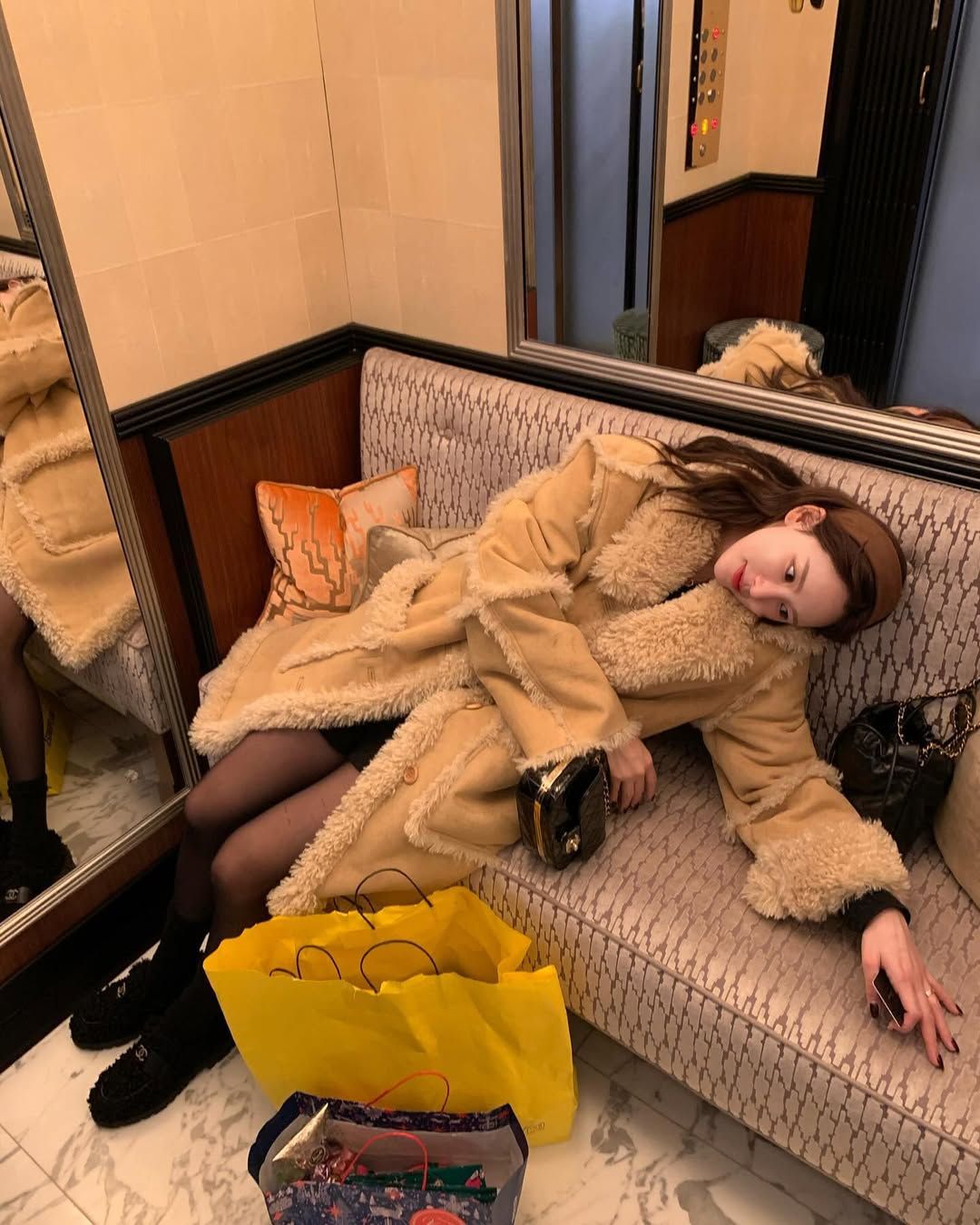 시어링 코트에 블랙 미니 체인 백을 매치해 로맨틱한 분위기를 연출한 이나연 / @inayommi