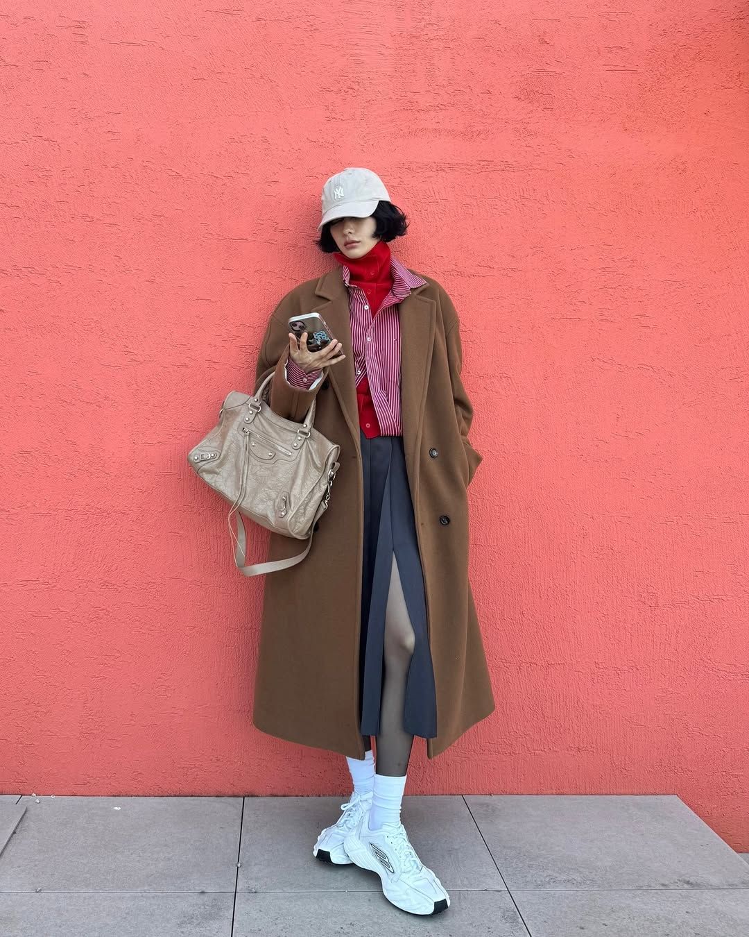 레드 컬러 이너와 셔츠 위에 짙은 카멜 컬러의 코트를 선택해 개성을 더한 나나 / @jin_a_nana