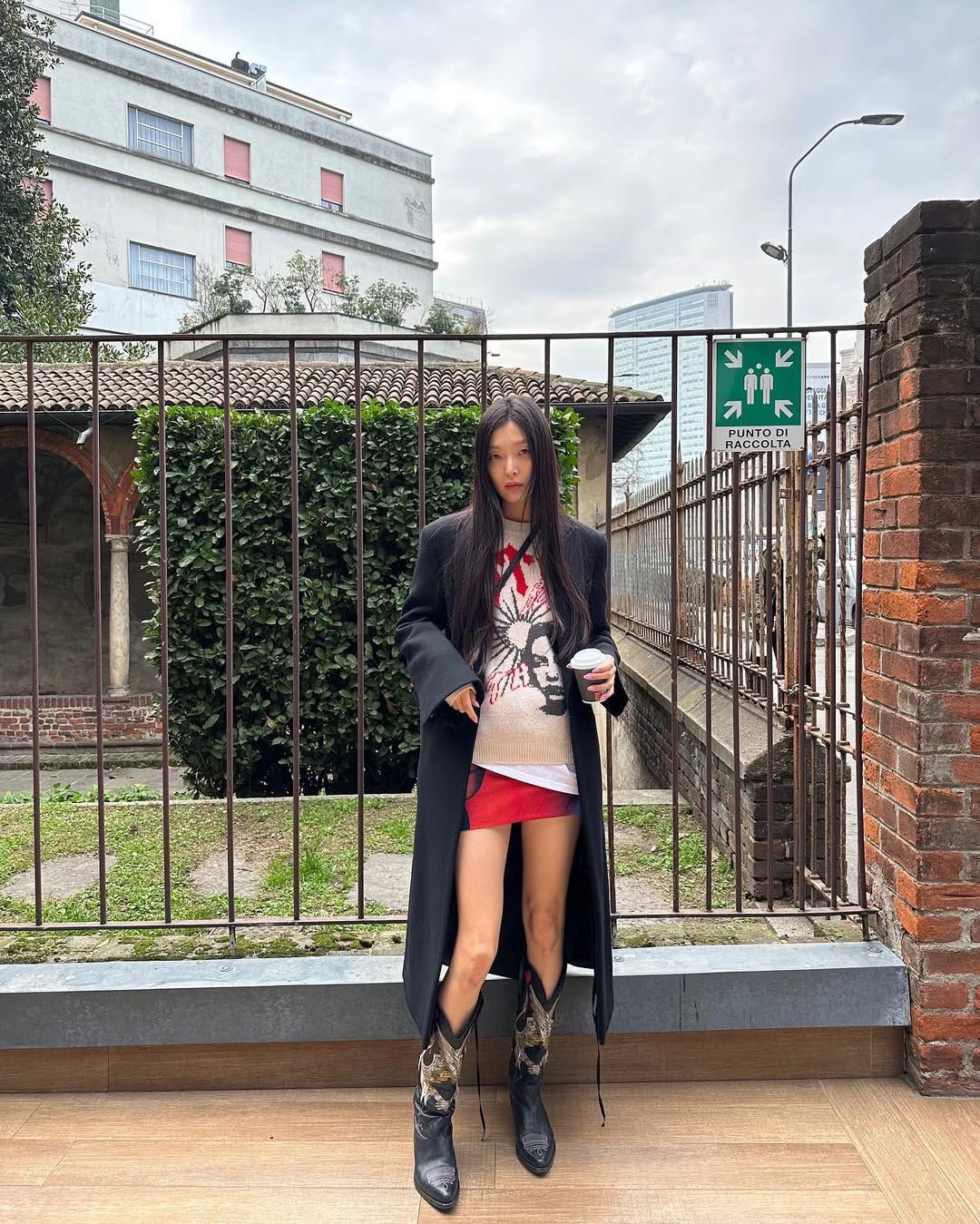 블랙 롱코트에 비비드한 레드 미니 스커트, 웨스턴 부츠를 더해 힙한 무드를 연출한 김성희 / @_sungheekim