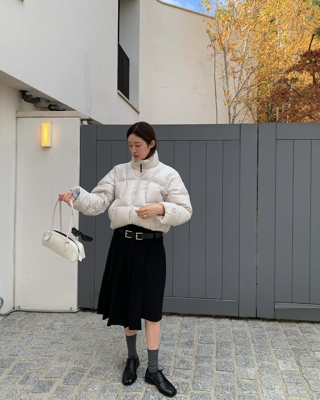 숏 패딩과 함께 블랙 플리츠스커트, 로퍼를 착용해 단정한 룩을 완성한 차정원 / @ch_amii