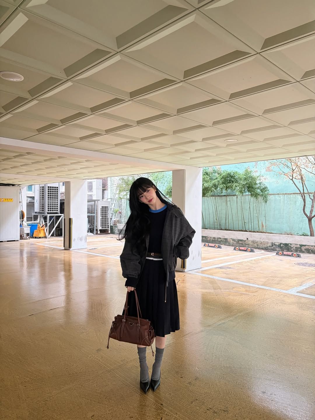 블랙 플리츠 미디스커트와 스틸레토 힐의 조합으로 우아한 분위기를 연출한 카리나 / @katarinabluu