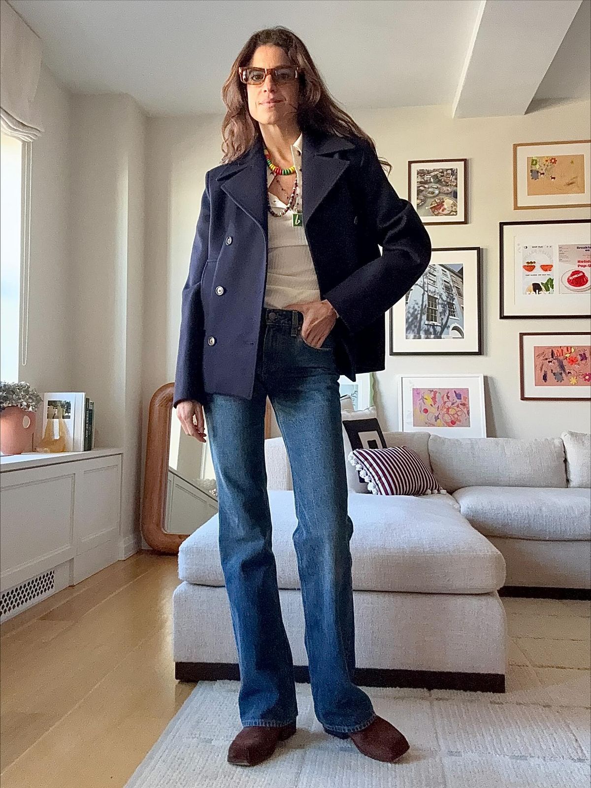 시가렛 데님 위에 네이비 피 코트를 더해 제복이 연상되는 깔끔한 룩을 연출한 @leandramcohen