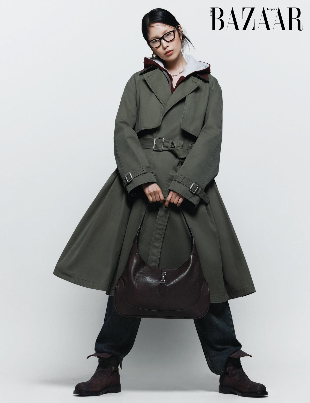 트렌치코트는 Dior. 이너로 착용한 후디 집업은 Maison Margiela. 팬츠는 Isabel Marant. 안경은 Gucci by Kering Eyewear. 귀고리는 11만원대, 목걸이는 15만원 Ami. ‘구찌 재키’ 백은 Gucci. 콤배트 부츠는 Burberry.