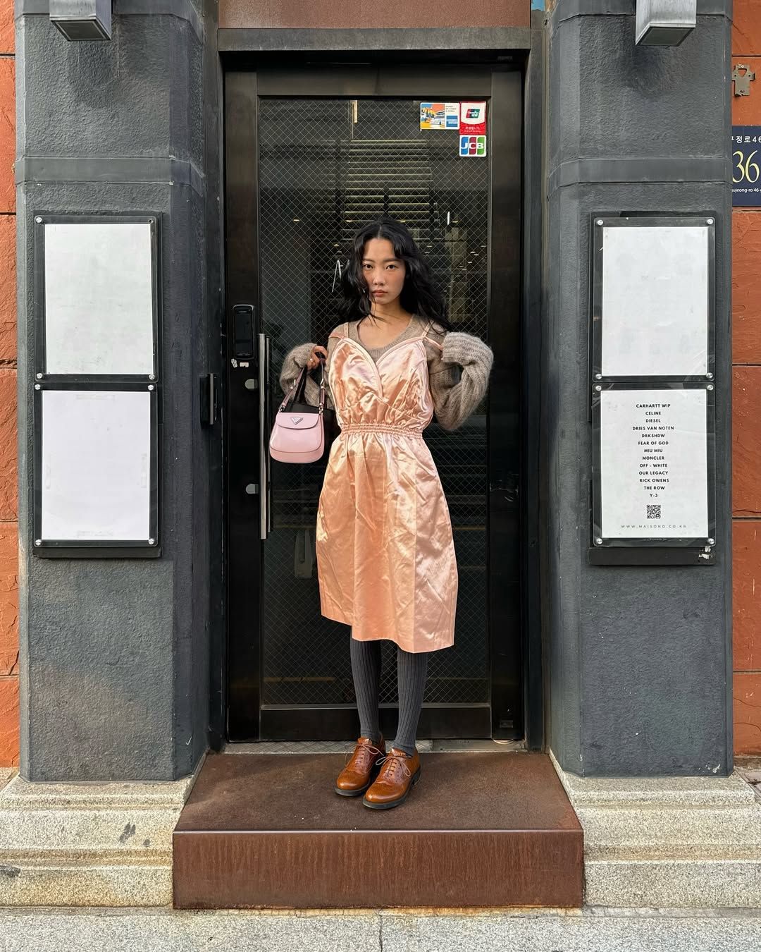 베이지 니트와 핑크 슬립 드레스를 레이어드하고 핑크 컬러의 프라다 미니 백을 들어 사랑스러운 무드를 완성한 박민주 / @mjbypp