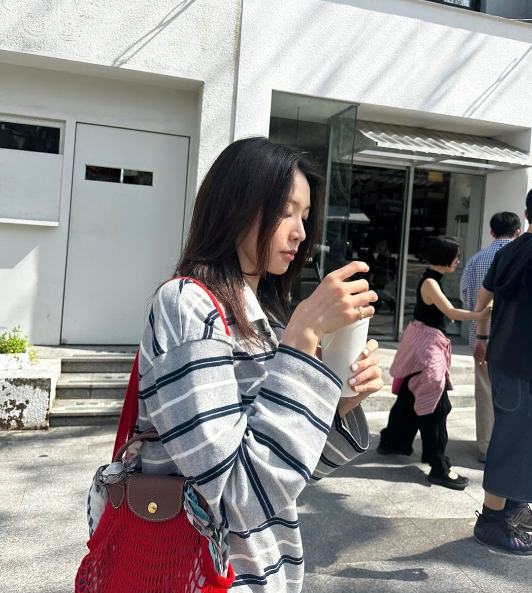 스트라이프 럭비 티셔츠와 레드 컬러의 네트 백을 더해 화사한 봄 룩을 완성한 최미나수 / @minadori222