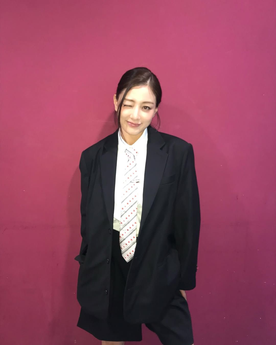 블랙 수트에 하트 패턴 넥타이를 매치해 유니크한 룩을 완성한 지효 / @_zyozyo