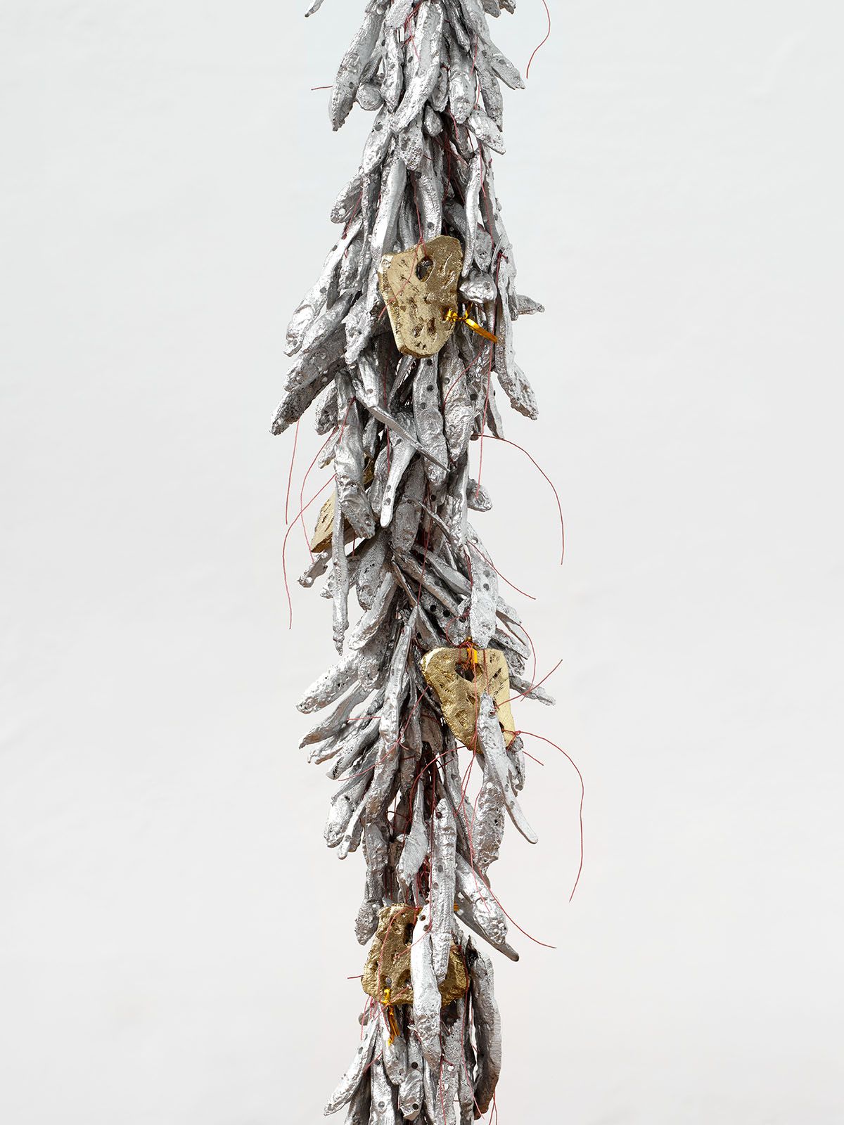 Lotus L. Kang, Tract XXIV, 2025, Cast aluminum anchovies, cast bronze lotus root, metallic twist ties, nylon, Approx. 305x13x13cm, Installation dimensions variable. Courtesy the artist. Photo © Paul Salveson 