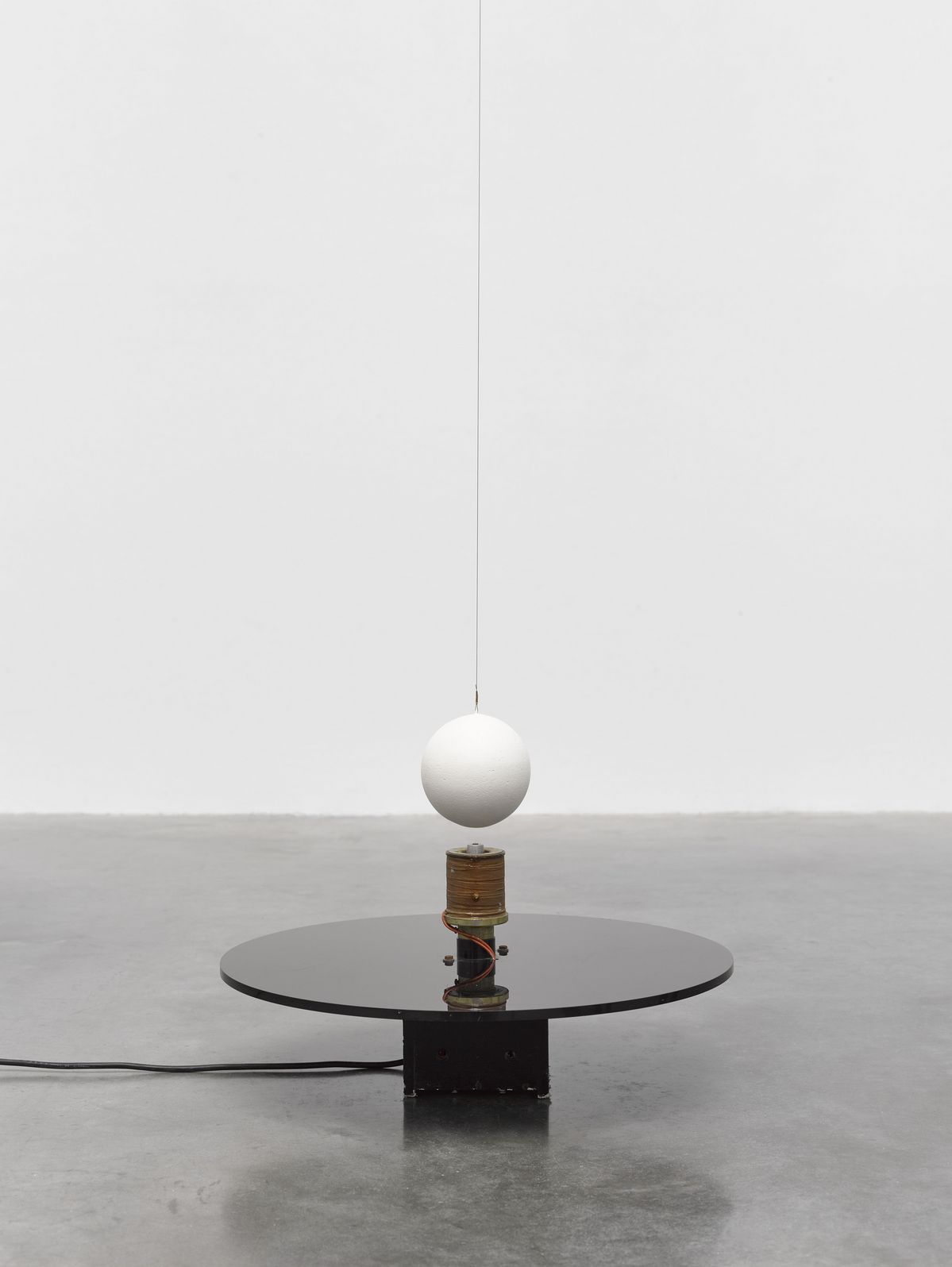 Takis Electromagnetic Sphere 1970 Plexiglas, electromagnet, cork sphere, magnet and wire 38.8 x 55 x 55 cm | 15 1/4 x 21 5/8 x 21 5/8 in. © Takis Foundation/ADAGP, Paris and DACS, London 2026. Photo © White Cube (Theo Christelis)