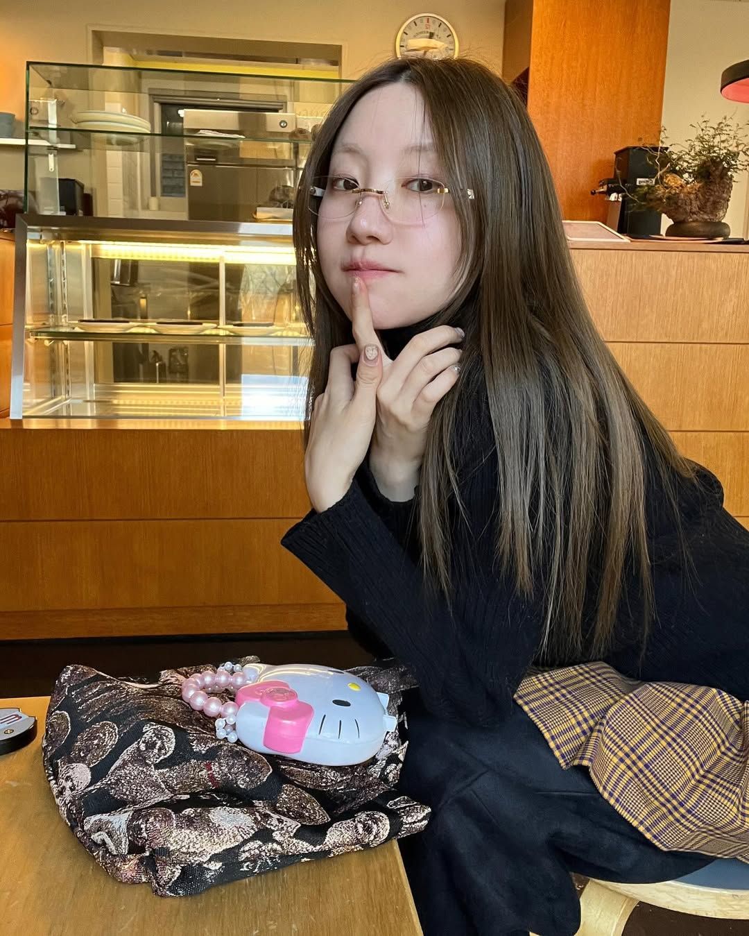 블랙 니트와 체크 미니스커트에 무테 안경을 더해 빈티지한 분위기를 연출한 오눅 / @onnuk_