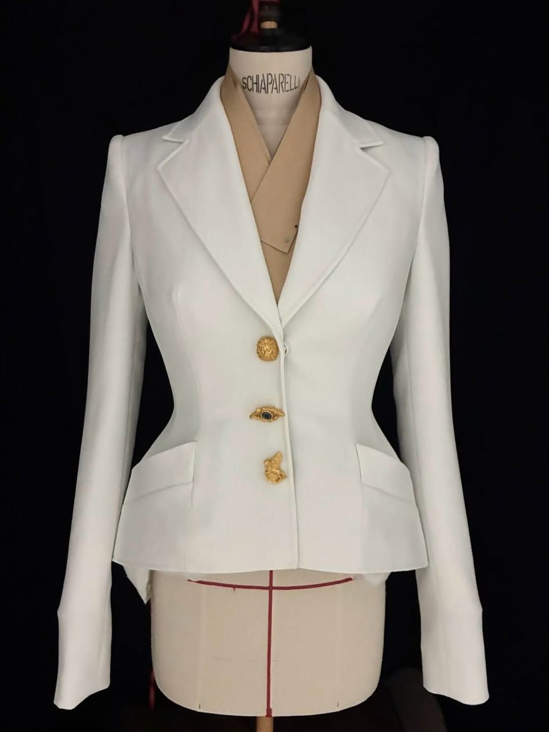 잘록한 허리와 골드 버튼으로 완성한 아이보리 재킷 @Schiaparelli