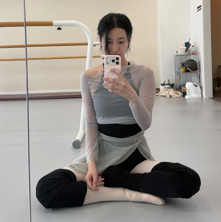 시스루 티셔츠와 랩 스커트를 착용한 수지