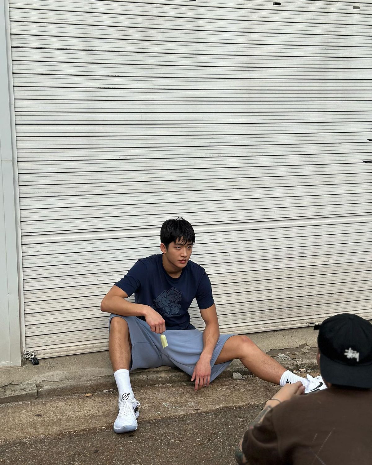 네이비 티셔츠와 그레이 쇼츠로 완성한 스포티한 데일리 룩.