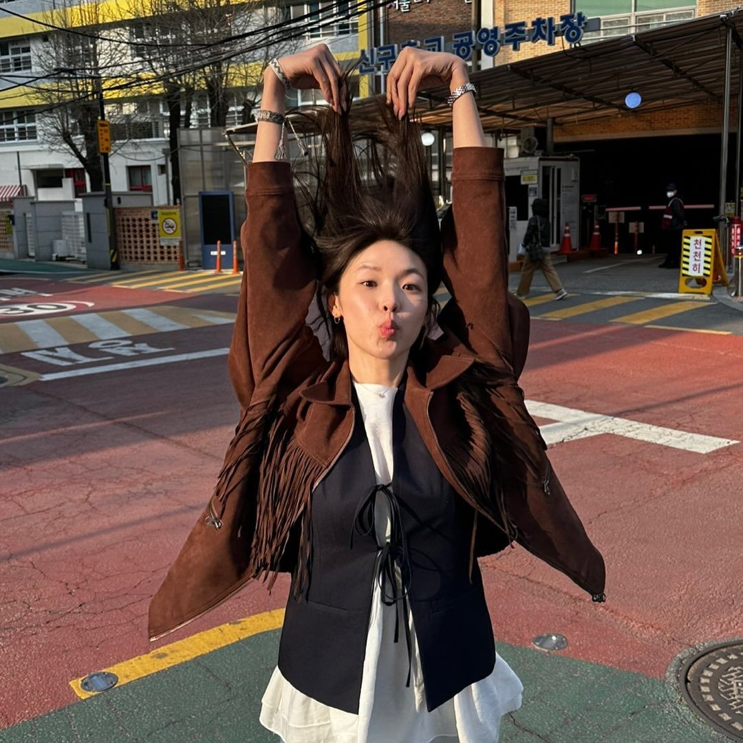 브라운 스웨이드 재킷과 러플 톱, 리본 베스트를 레이어드한 최미나수의 색다른 가을 룩./ @choimina_su