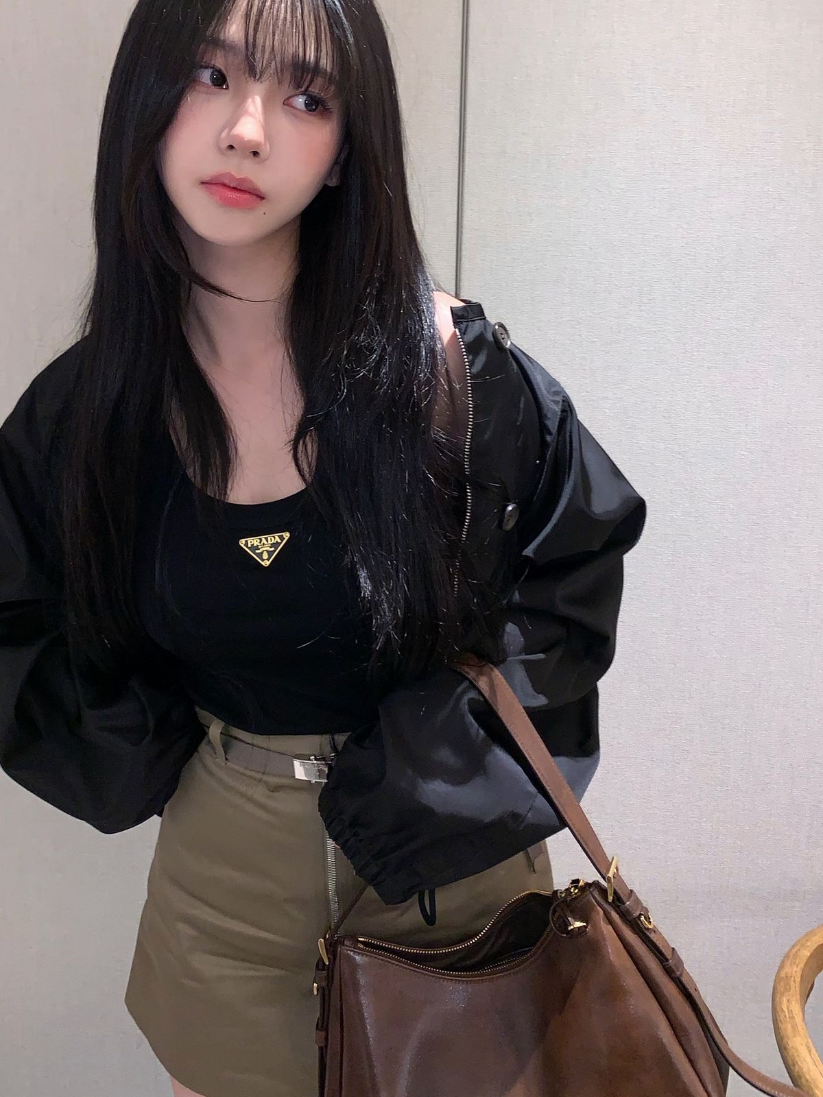 블랙 바람막이와 카키 쇼츠, 빈티지한 브라운 레더 백으로 시크한 데일리 룩을 선보인 카리나. / @katarinabluu