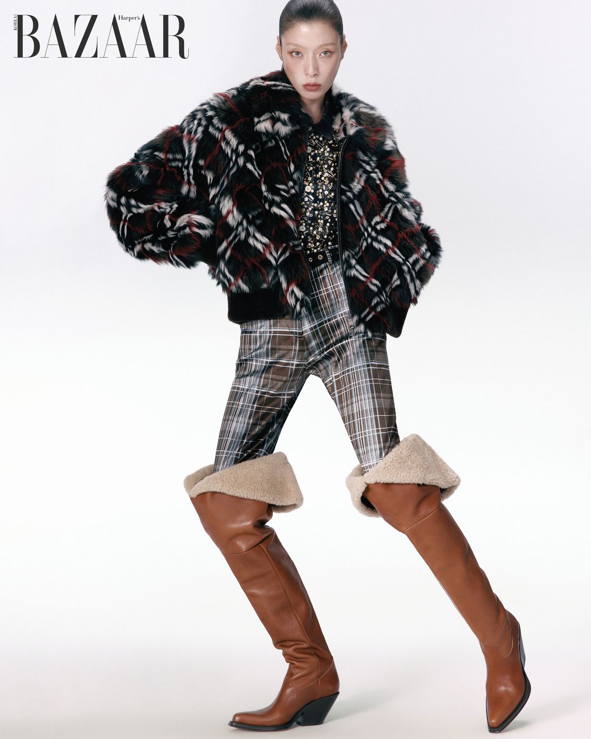 시어링 보머 재킷은 Burberry. 옷핀 장식 셔츠는 Sacai. 새틴 팬츠는 Acne Studios. 펀칭 벨트는 N°21. 시어링 디테일 니하이 부츠는 Chloé.