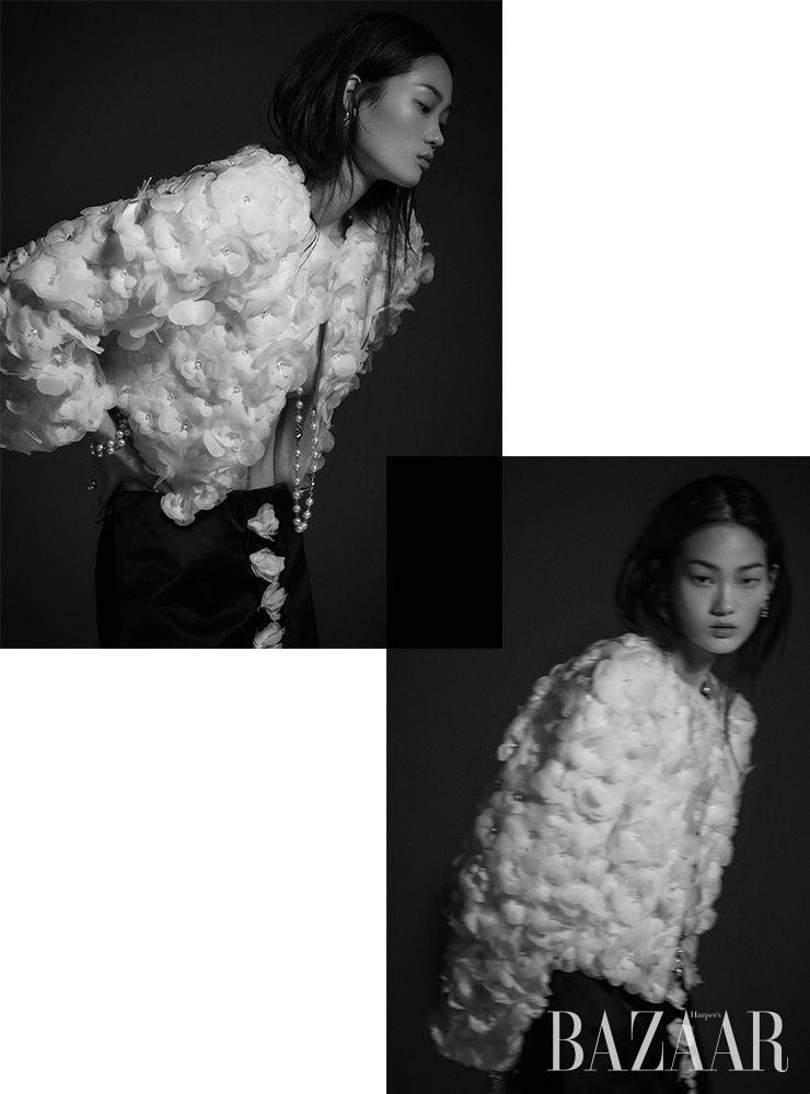 카멜리아 모티프 재킷, 새틴 소재 스커트, 귀고리, 진주 목걸이, 팔찌는 모두 Chanel.