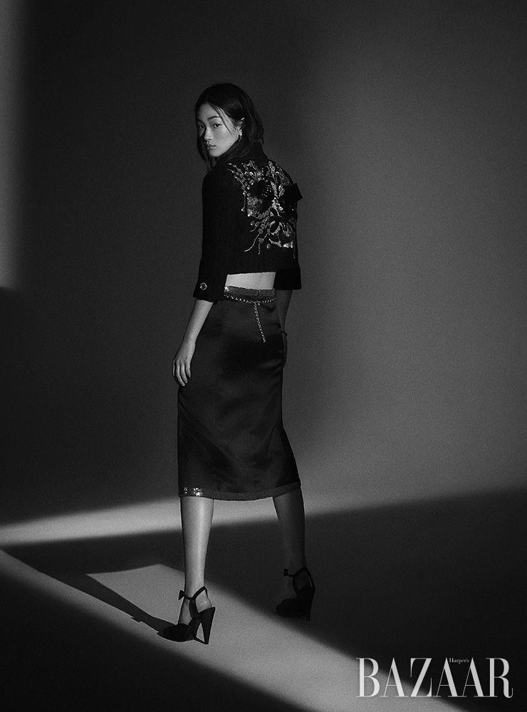 크롭트 재킷, 스커트, 드롭 귀고리, 팔찌, 체인 벨트, 슈즈는 모두 Chanel.