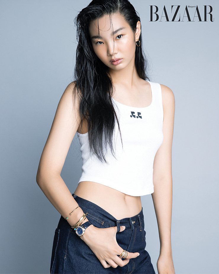 18캐럿 세드나 골드에 다이아몬드가 파베 세팅된 ‘코-액시얼 마스터 크로노미터’ 워치는 1천7백만원대 Omega. ‘T 와이어 후프’ 이어링은 Tiffany & Co.. 오른팔 위부터 그린 말라카이트 카보숑이 세팅된 ‘포제션 오픈’ 뱅글, 터쿼이즈 카보숑이 세팅된 ‘포제션 오픈’ 뱅글은 Piaget. 중간에 착용한 옐로 골드 브레이슬릿, 검지에 착용한 링은 ‘코코 크러쉬’ 컬렉션 Chanel Fine Jewelry. 톱은 3만원대 Rest & Recreation. 데님 팬츠는 13만원대 Cos.