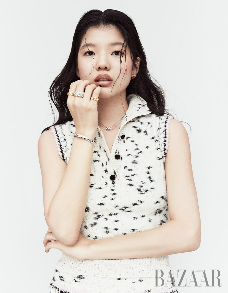 레이어드하여 연출한 듯한 효과를 주는 ‘코코 크러쉬’ 귀고리, 검지에 착용한 옐로 골드 반지, 중지에 착용한 볼드한 화이트 골드 반지, 소지에 착용한 베이지 골드에 다이아몬드가 세팅된 반지, 퀼팅 모티프의 팔찌, 화이트 골드에 다이아몬드가 장식된 목걸이는 모두 ‘코코 크러쉬’ 컬렉션 Chanel Fine Jewelry. 니트 톱, 스커트는 Chanel.