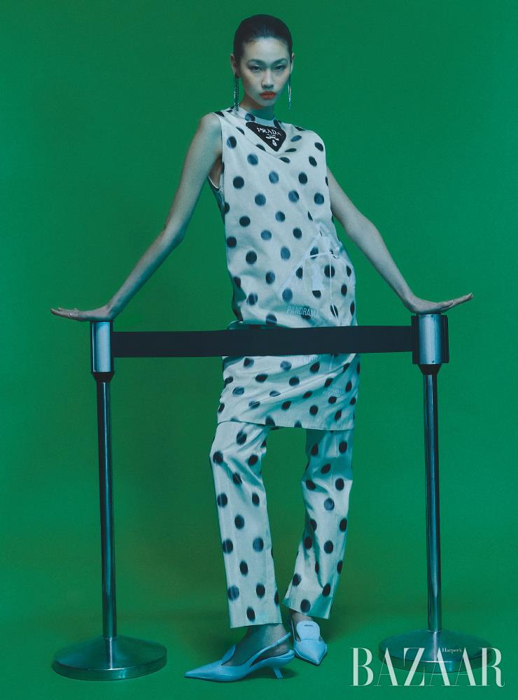 태피터 슬리브리스 드레스, 팬츠, 드롭 귀고리, 나일론 슬링백 슈즈는 모두 Prada.