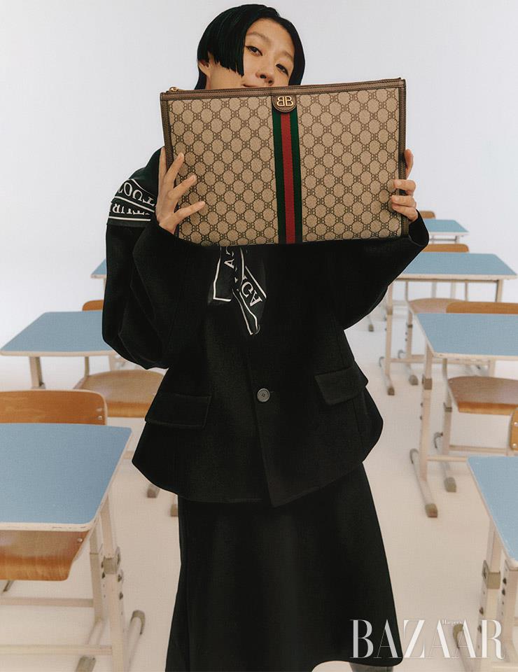 라운드 숄더 재킷, 미디스커트, 쿠튀르 스카프, ‘더 해커 프로젝트’ 랩톱 파우치, 블레이드 부츠는 모두 Balenciaga.