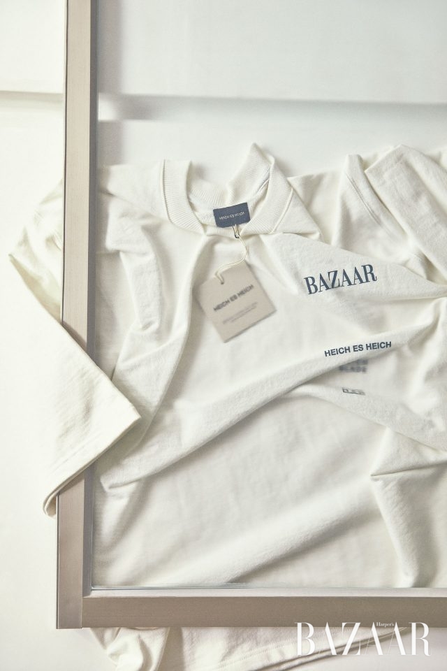 뒷면에는 의 슬로건을 새기고 앞면은 모던하게 디자인한 티셔츠는 Heich Es Heich 제품.