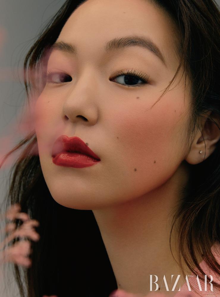 골드 펄이 가미된 피치 하이라이터와 핑크 코럴 블러셔로 이뤄진 샤넬 ‘플뢰르 드 쁘렝땅’으로 갓 피어난 꽃의 생기를 표현했다. 코튼 실크 소재의 톱은 Chanel.