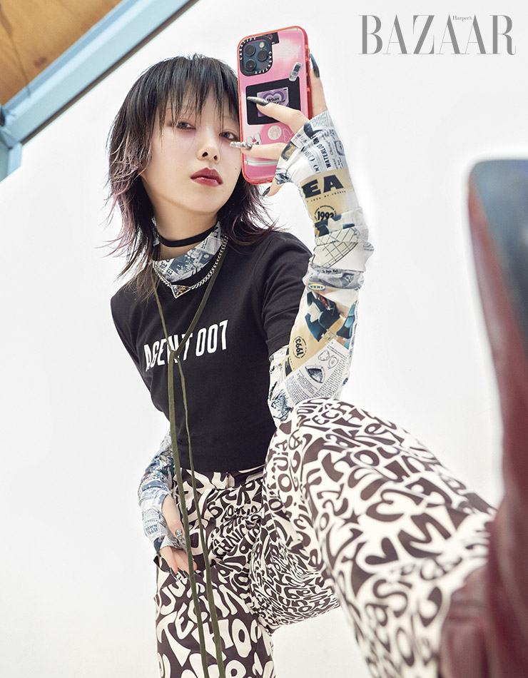 레터링 티셔츠는 MICHAEL Michael Kors. 레터링 하이웨이스트 팬츠는 House of Sunny by Beaker. 스퀘어 토 앵클부츠는 Rekken. 레이어드한 프린트 저지 톱은 스타일리스트 소장품. 초커, 펜던트 목걸이는 개인 소장품.  