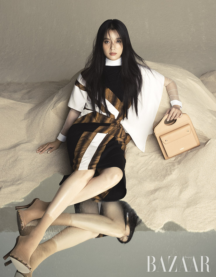 드레스, 이너로 입은 터틀넥 보디수트, 미니 ‘포켓’ 백, 삭스 부티는 모두 Burberry.