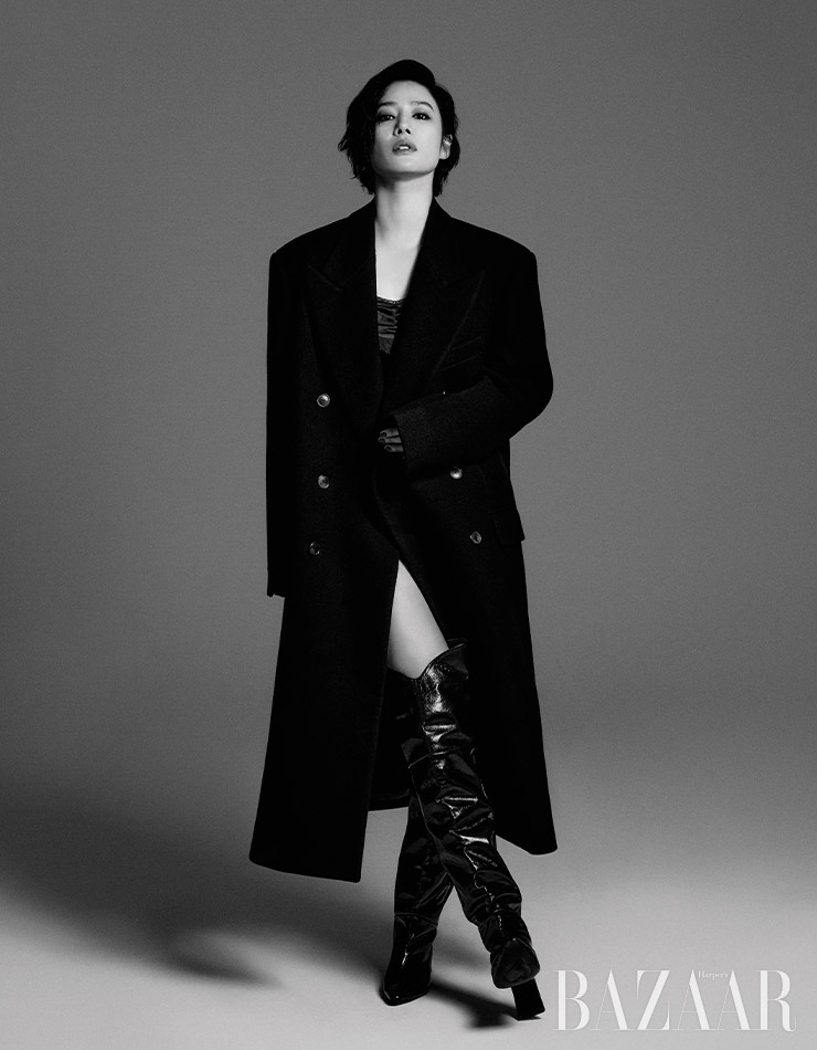 오버사이즈 코트는 Recto. 슬리브리스 톱은 Helmut Lang by Yoox. 니하이 부츠는 Rachel Cox.