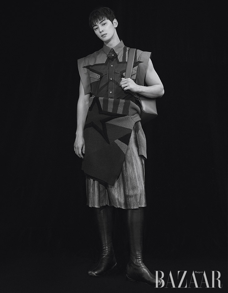 슬리브리스 셔츠, 허리에 두른 스웨터, 스커트, 니삭스 부츠, 레더 백팩은 모두 Burberry.