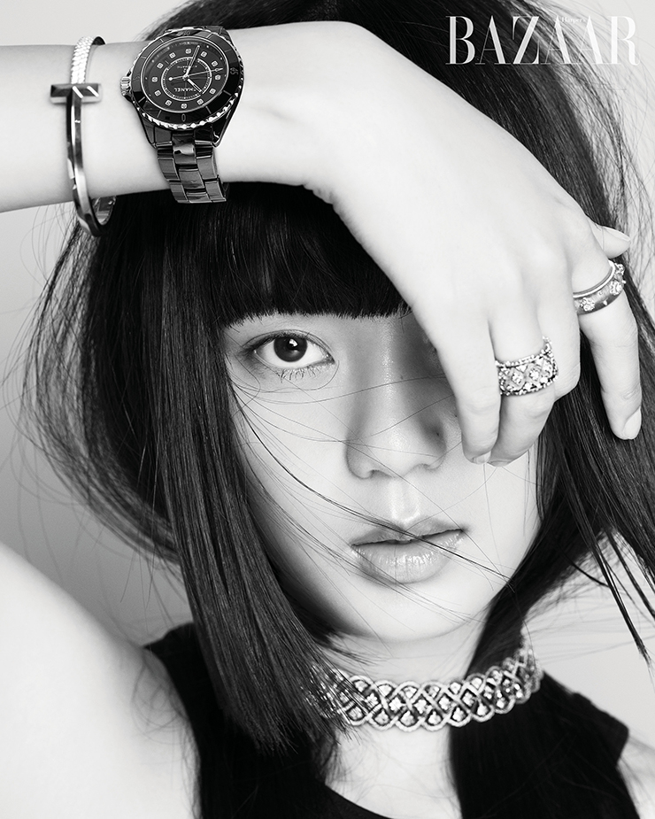 12개의 다이아몬드가 세팅된 블랙 세라믹 소재의 ‘J12’ 워치는 Chanel Watches. 오른팔에 착용한 ‘T1’ 뱅글은 Tiffany & Co.. 검지에 착용한 옐로·화이트 골드에 다이아몬드가 세팅된 ‘밴드’ 링은 1천8백만원대, 약지에 착용한 나뭇잎 모티프의 로제트 장식 ‘마크리 이터넬레’ 링은 8백만원대, ‘에뚜왈레’ 네크리스는 2천8백만원대 모두 Buccellati. 탱크톱은 4만원대 The Open Product.