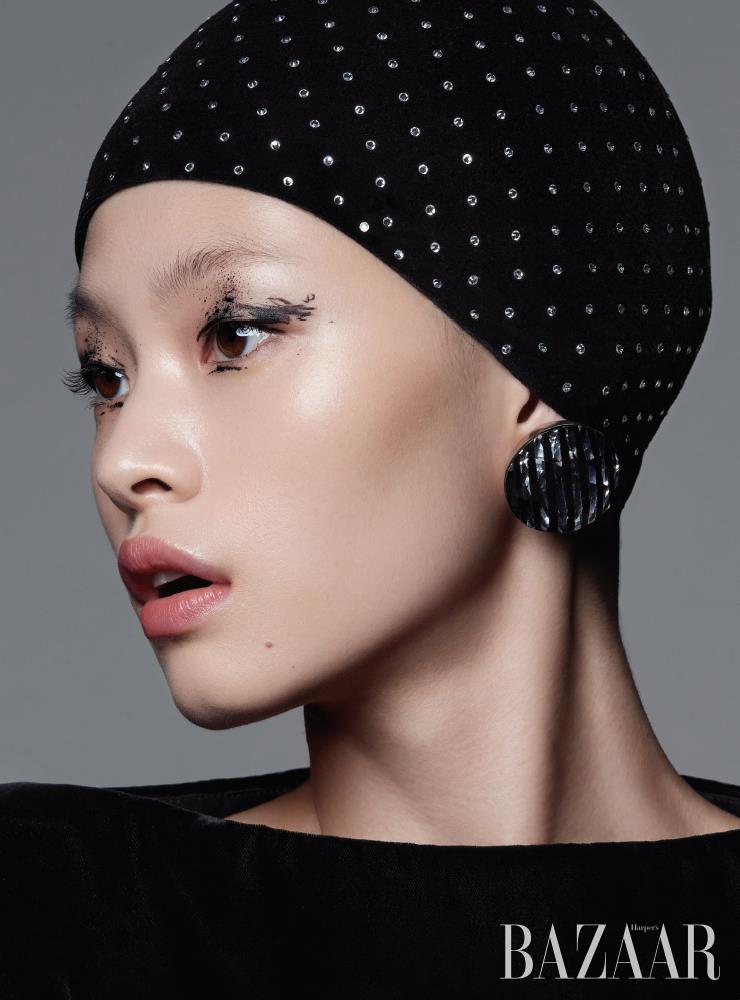 비즈 장식 모자, 벨벳 미니 드레스, 볼드한 귀고리는 모두 Saint Laurent by Anthony Vaccarello. 