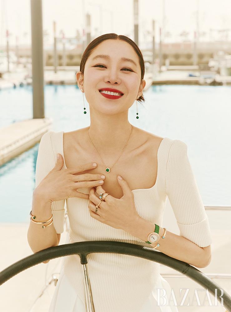 18K 핑크 골드 체인에 말라카이트가 세팅된 ‘포제션’ 이어링, 다이아몬드가 둘러싼 말라카이트가 매력적인 ‘포제션 럭키 펜던트’ 네크리스, 오른팔에 착용한 ‘포제션 더블 투어’ 뱅글, 왼손 검지에 착용한 터쿼이즈가 세팅된 ‘포제션 오픈’ 링, 18K 핑크 골드에 다이아몬드가 세팅된 ‘포제션’ 링, 중지에 착용한 다이아몬드가 세팅된 ‘포제션 오픈’ 링, 그린 앨리게이터 스트랩의 ‘포제션’ 워치, 양쪽 끝에 터쿼이즈와 다이아몬드가 세팅된 ‘포제션 오픈’ 뱅글은 모두 Piaget. 니트 톱, 팬츠는 Khaite by 10 Corso Como.