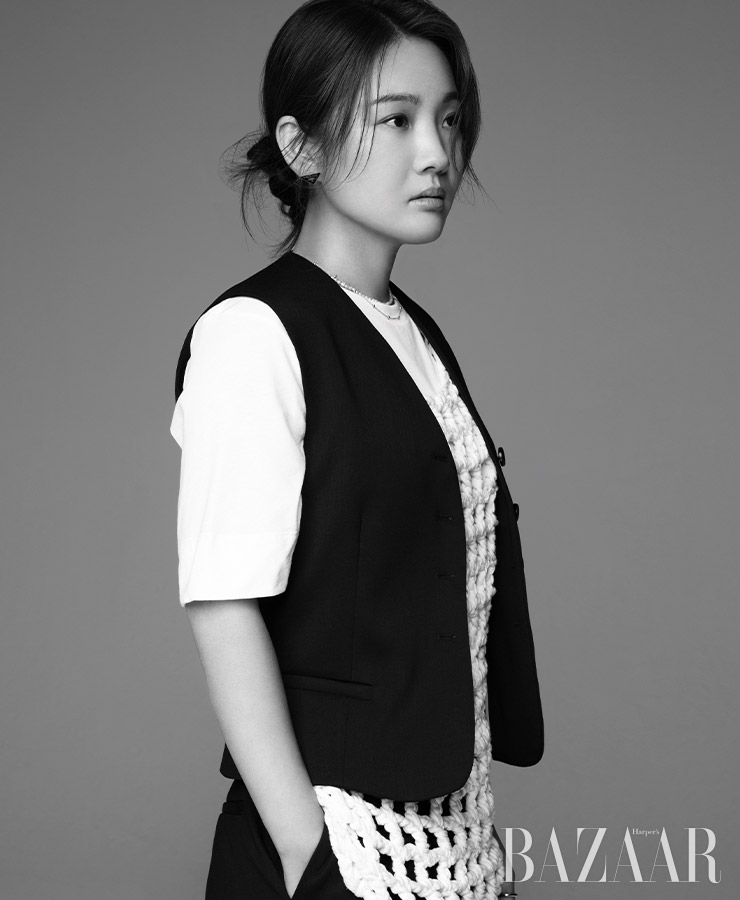 톱은 Ganni.니트 톱은 Eenk. 베스트, 팬츠는 Cos.목걸이는 Verutum.이어링은 Prada.
