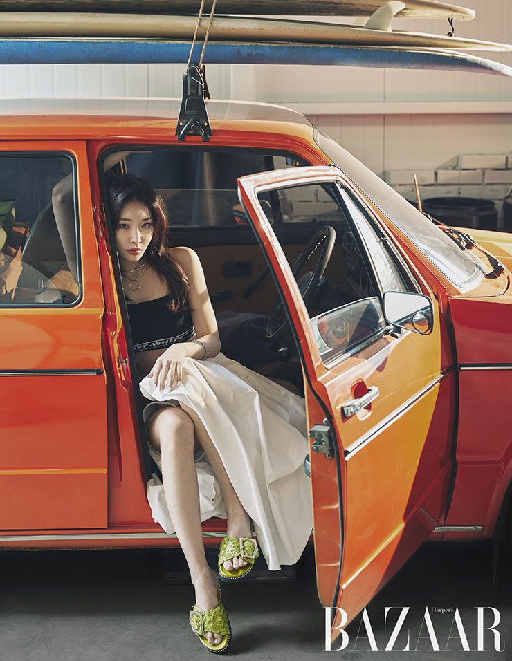 라임 그린 컬러의 비즈가 화려한 벨티드 장식의 문빔 2(Moonbeam 2) 슬라이드는 29만8천원, Suecomma bonnie. 크롭트 톱은 Off-white™, 화이트 스커트는 The centaur, 브레이슬릿은 Mama casar.