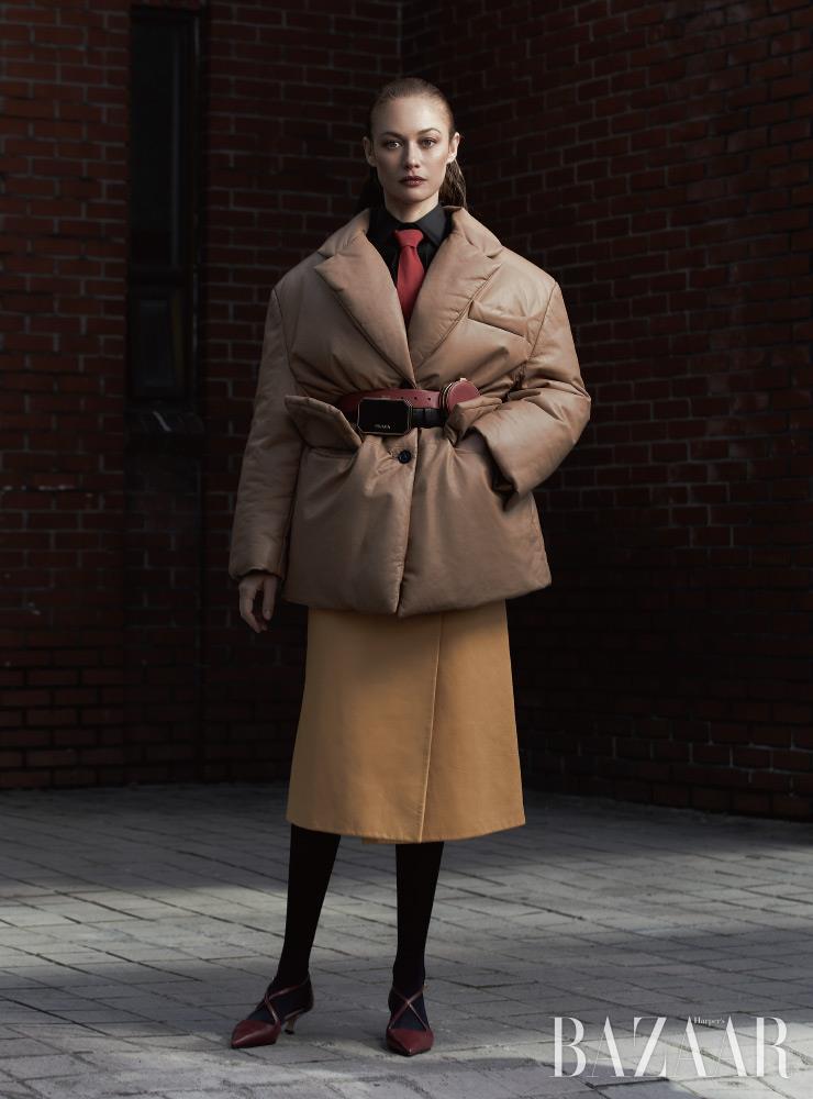 패딩 재킷, 셔츠, 레더 스커트, 타이, 벨트 백은 모두 Prada. 스트랩 힐은 Rachel Cox. 타이츠는 에디터 소장품.