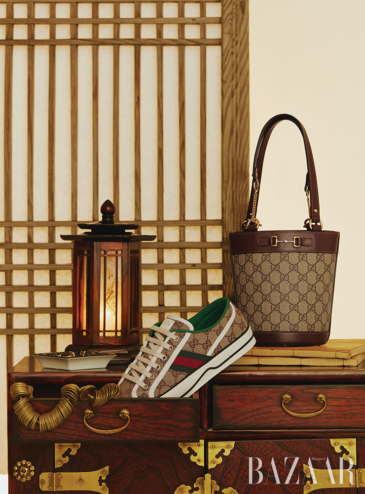 GG 수프림 캔버스의 ‘구찌 홀스빗 1955’ 스몰 버킷 백, ‘테니스 1977’ 스니커즈는 Gucci.