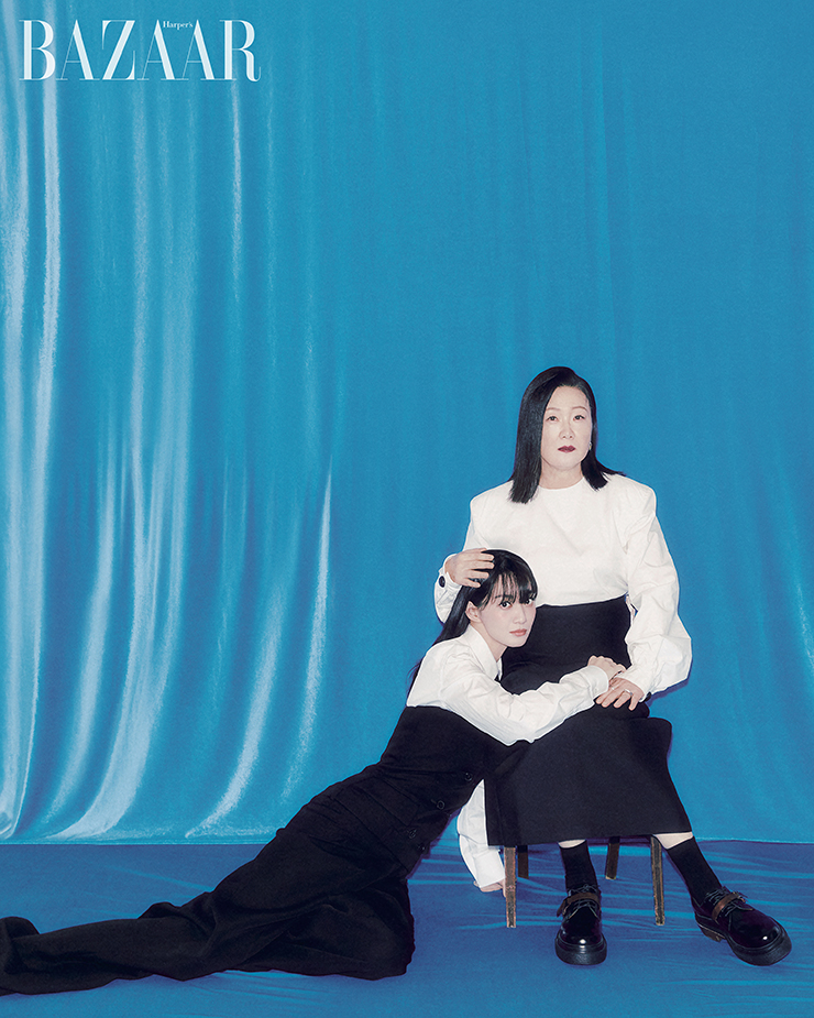 김해숙이 착용한 톱, 슈즈는 Tod’s. 귀고리, 반지는 Lost In Echo. 검지에 낀 실버 링은 본인 소장품. 스커트, 양말은 스타일리스트 소장품. 신민아가 착용한 셔츠, 점프수트, 타이, 슈즈는 Alexander McQueen. 귀고리, 반지는 모두 Didier Dubot.