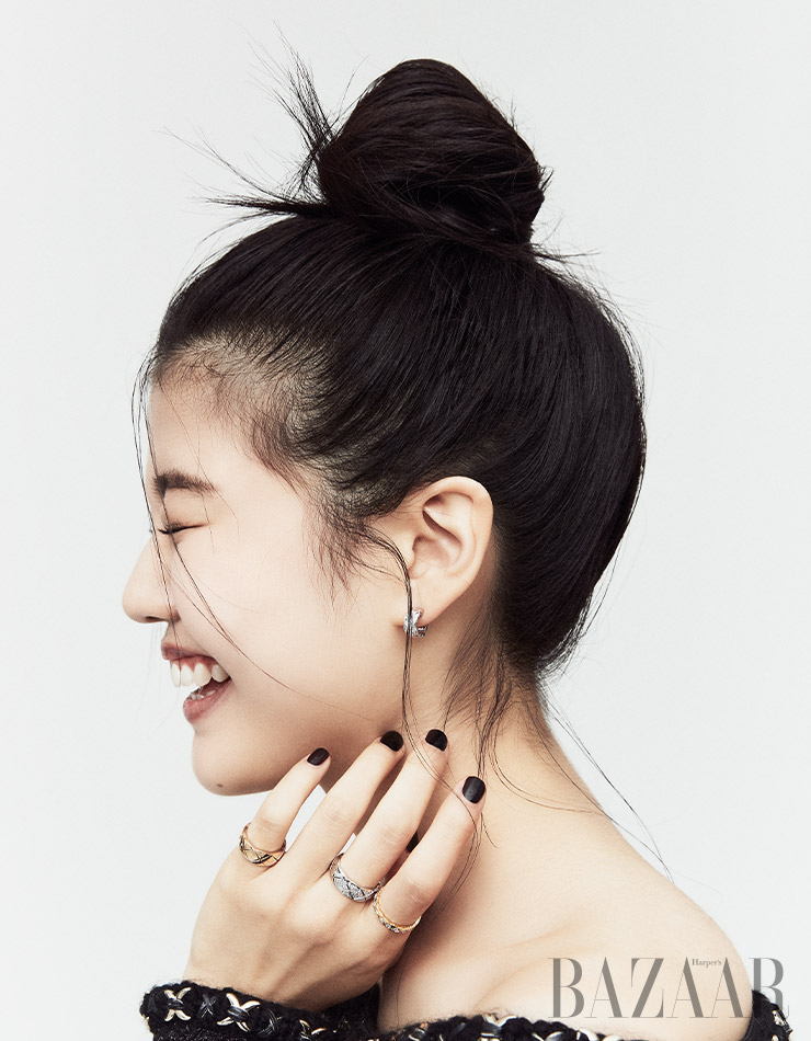퀼팅 모티프 귀고리, 검지에 낀 18K 옐로 골드에 18개의 다이아몬드가 세팅된 반지, 중지에 낀 31개의 라운드 컷 다이아몬드가 세팅된 링, 소지에 낀 베이지 골드 미디엄 링은 모두 ‘코코 크러쉬’ 컬렉션 Chanel Fine Jewelry. 트위드 재킷은 Chanel.