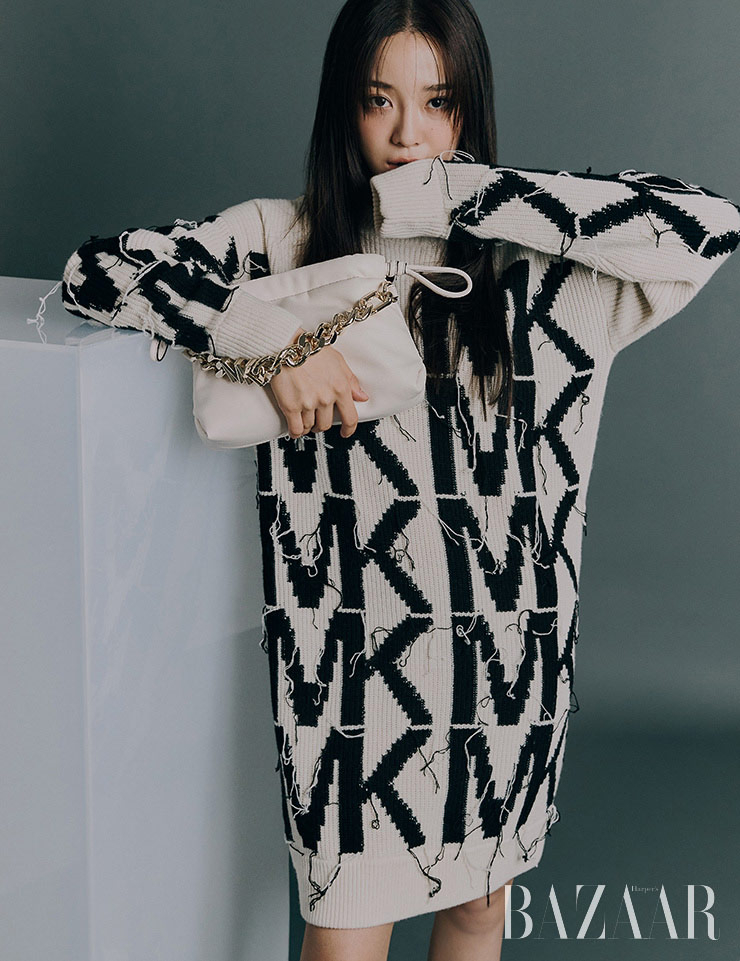MK 로고 디테일이 가미된 스웨터 드레스, 골드 컬러 체인 장식이 인상적인 리나 백은 모두 Michael Kors.