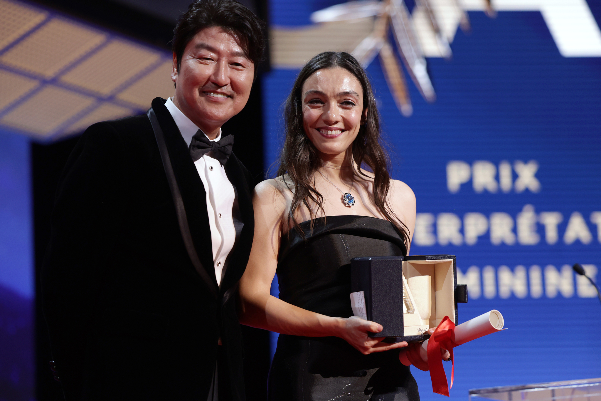 CANNES, FRANCE - MAY 27: Merve Dizdar (R) receives The Best Actress Award for 'About Dry Grasses' from Song Kang-ho (L) during the closing ceremony during the 76th annual Cannes film festival at Palais des Festivals on May 27, 2023 in Cannes, France. (Photo by Pascal Le Segretain/Getty Images)