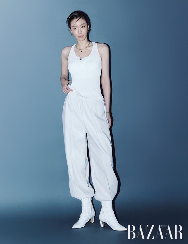 니트 슬리브리스 톱은 Bally. 화이트 팬츠는 Wovement. 체인 목걸이는 Roaju. 짧은 펜던트 목걸이는 Engbrox. 팔찌는 Tani by Minetani. 앵클부츠는 Magpie. 귀고리, 긴 펜던트 목걸이는 스타일리스트 소장품.