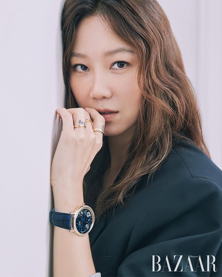 왼손에 착용한 세 개의 18K 핑크 골드 ‘포제션 웨딩’ 링, 자체 제작 910P 울트라-씬 기계식 셀프 와인딩 무브먼트를 장착한 ‘알티플라노 울티메이트 셀프 와인딩’ 워치는 Piaget. 재킷은 Celine.