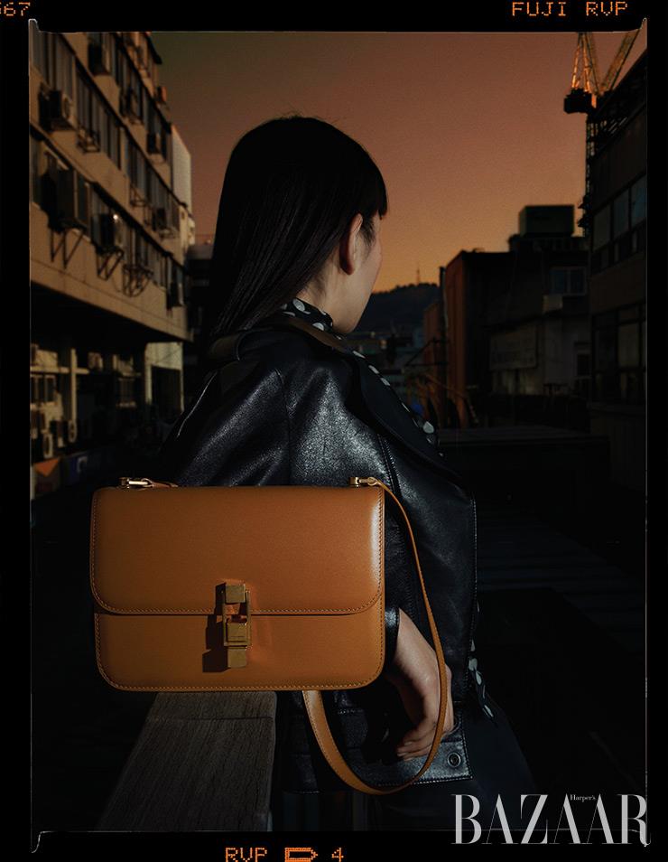 다크 선 ‘꺄레 샤첼’ 백, 양가죽 소재의 바이커 재킷, 도트 블라우스, 라텍스 레깅스는 모두 Saint Laurent by Anthony Vaccarello.
