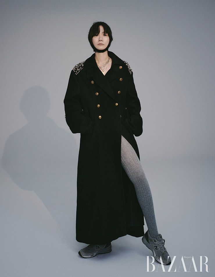 롱 코트, 발라클라바, 타이츠는 모두 Miu Miu. 코인 목걸이는 Portrait Report. 골드 코인 레이어드 목걸이는 Mamacasar. 실버 체인 목걸이는 MidnightmomentxAmondz. 스니커즈는 스타일리스트 소장품. 