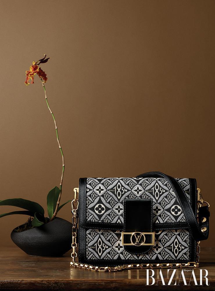 체인과 가죽, 두 개의 스트랩이 달린 ‘도핀’ 플랩 백은 Louis Vuitton. JBZ_